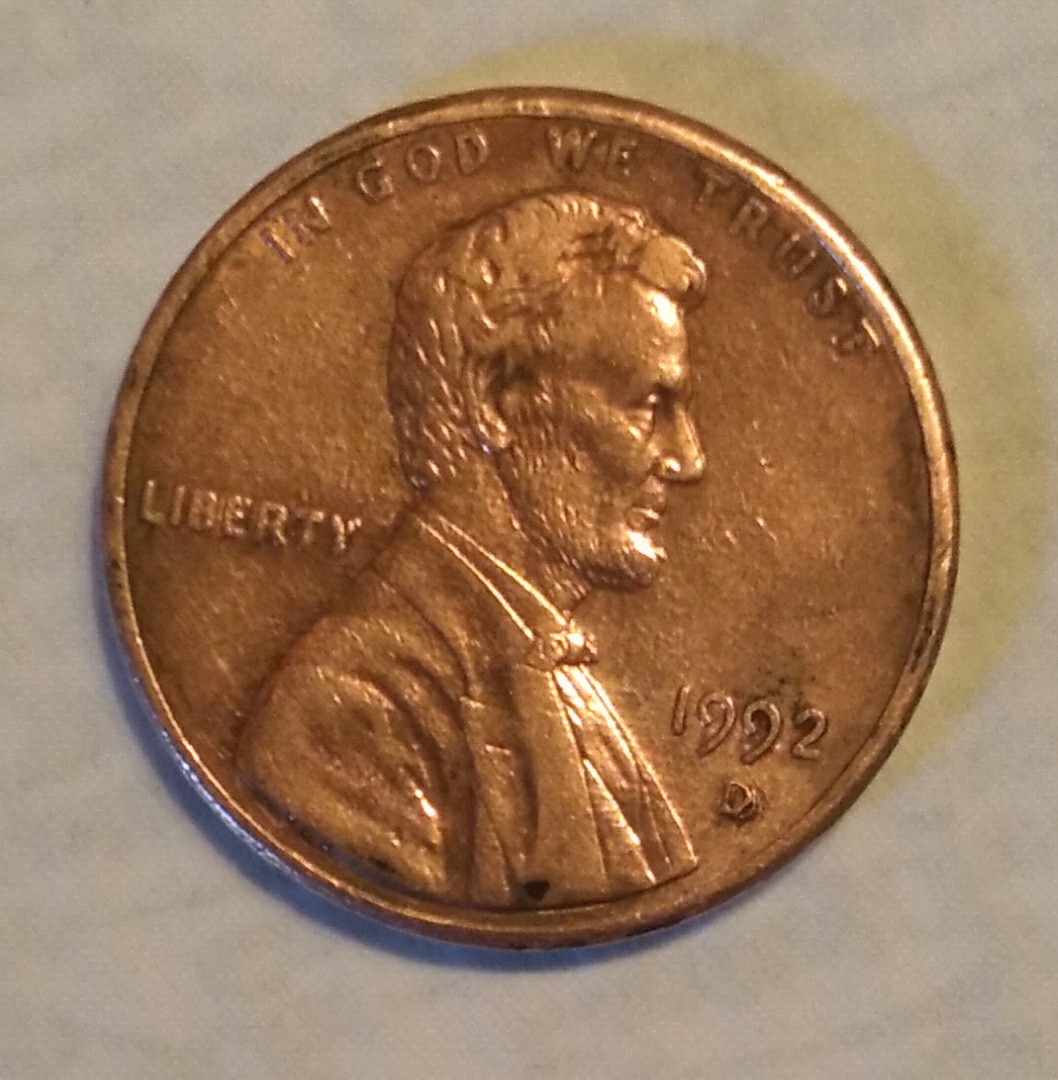 1992 penny doubled die obverse error showing doubled letters in IN GOD WE TRUST under magnification